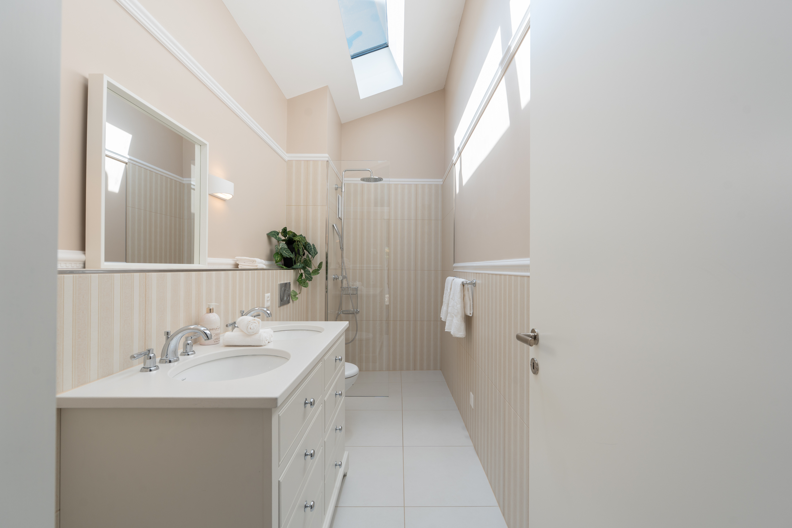 Helles Badezimmer mit Doppelwaschtisch und Walk-in-Dusche