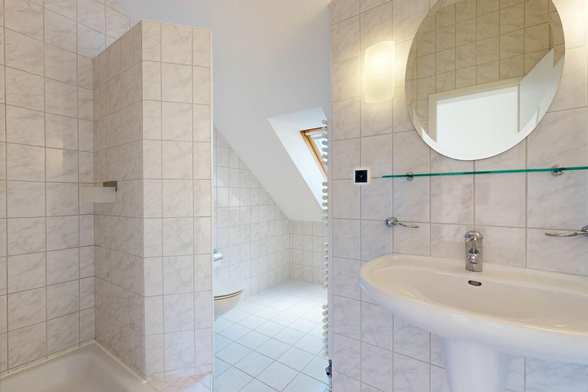 Badezimmer mit Badewanne, Waschtisch und Dachfenster