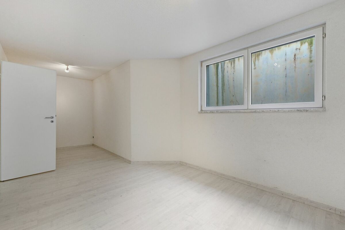 Leerer heller Raum mit Fenster und offener Tür