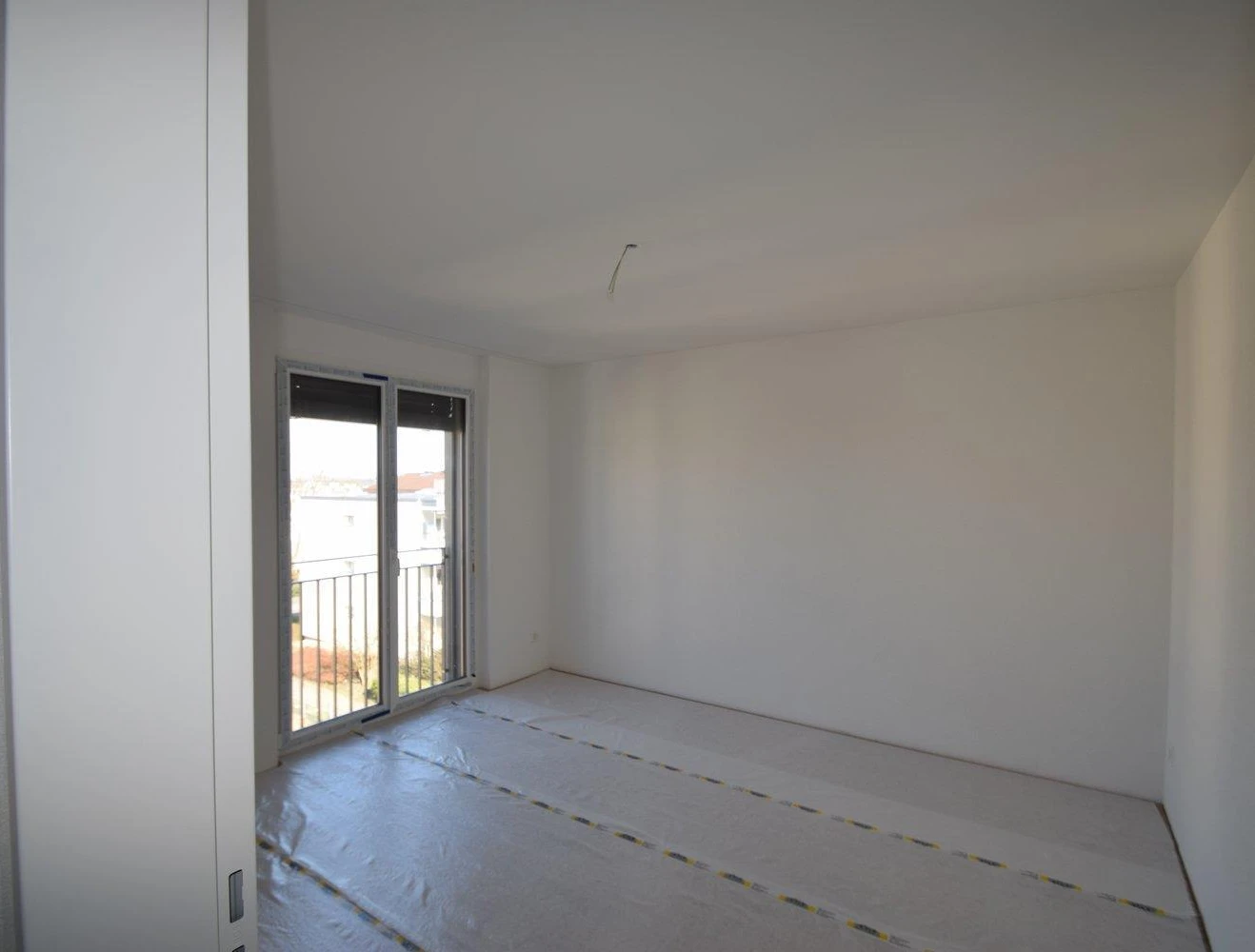 Helles, leeres Zimmer mit Balkonblick