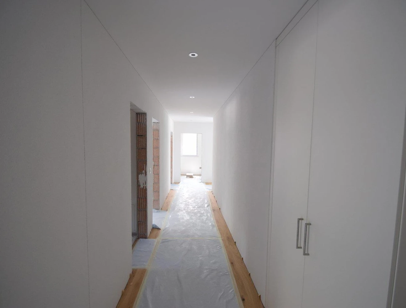 Langer Flur im Rohbau mit Abdeckfolie