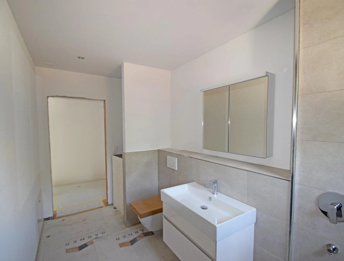 Modernes Badezimmer mit hellen Fliesen und Waschtisch