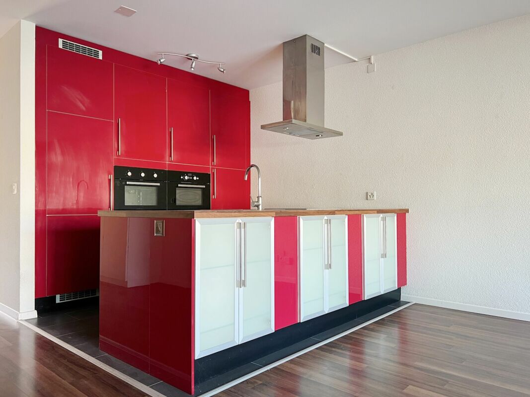 Moderne Küche mit roter Hochglanzfront und Kochinsel