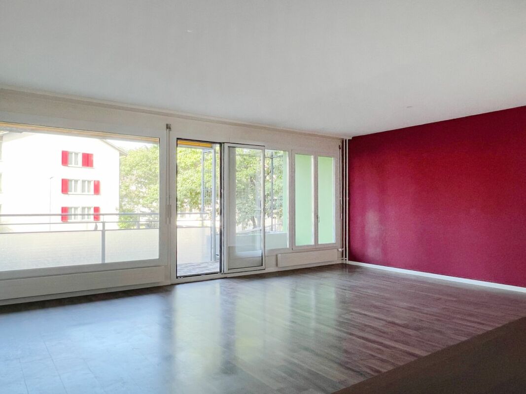 Heller Wohnraum mit Balkon und großem Fensterband