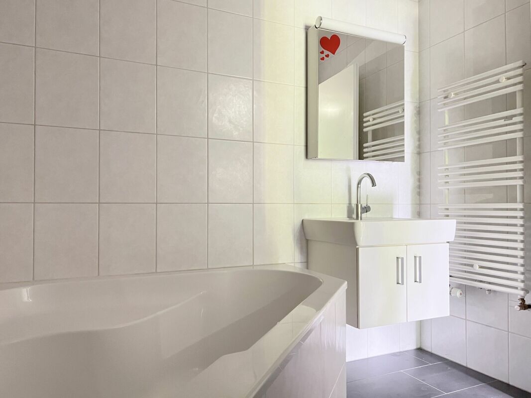 Helles Badezimmer mit Badewanne und Waschtisch