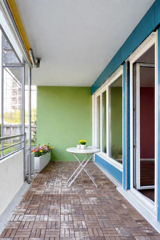 Überdachter Balkon mit Tisch und Pflanzen