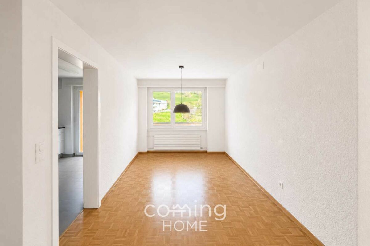 Heller leerer Raum mit Holzparkett und Fensterblick