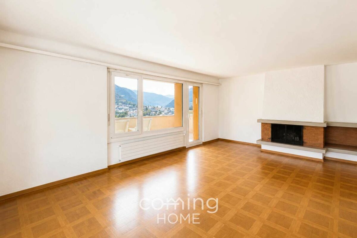 Wohnzimmer mit Kamin und Bergblick