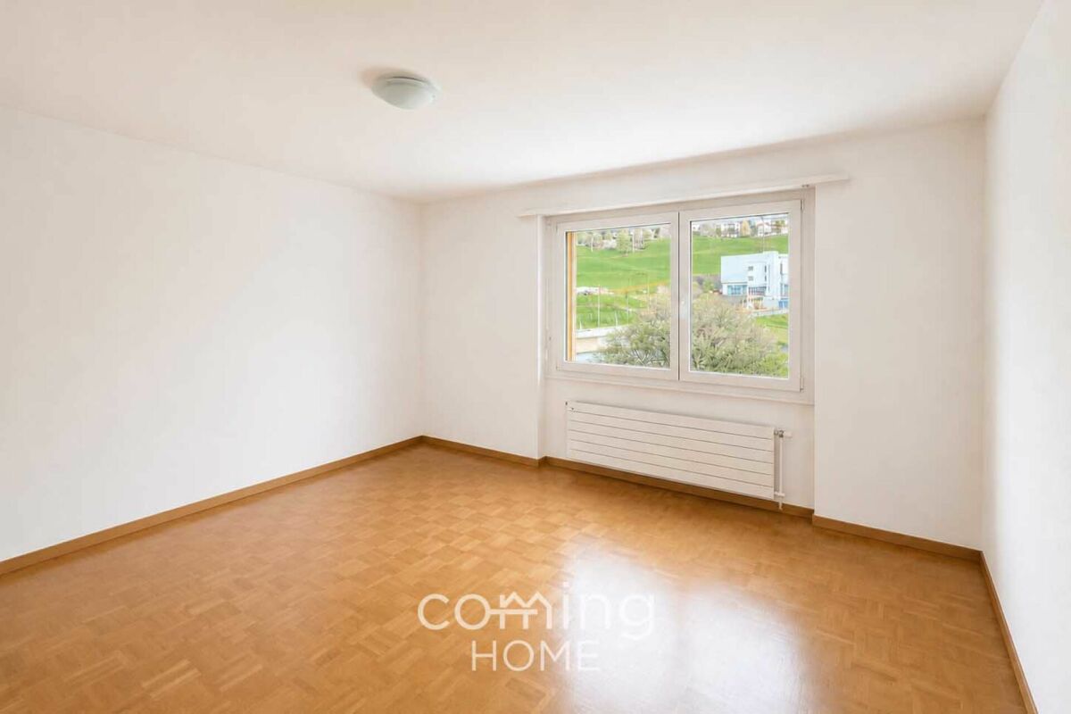 Leerer heller Wohnraum mit Fenster und Heizkörper