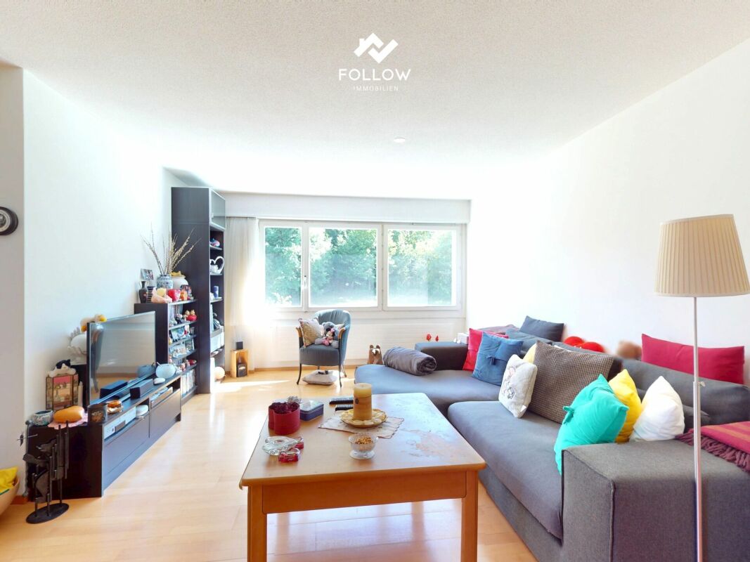 Helles Wohnzimmer mit Sofa und großer Fensterfront