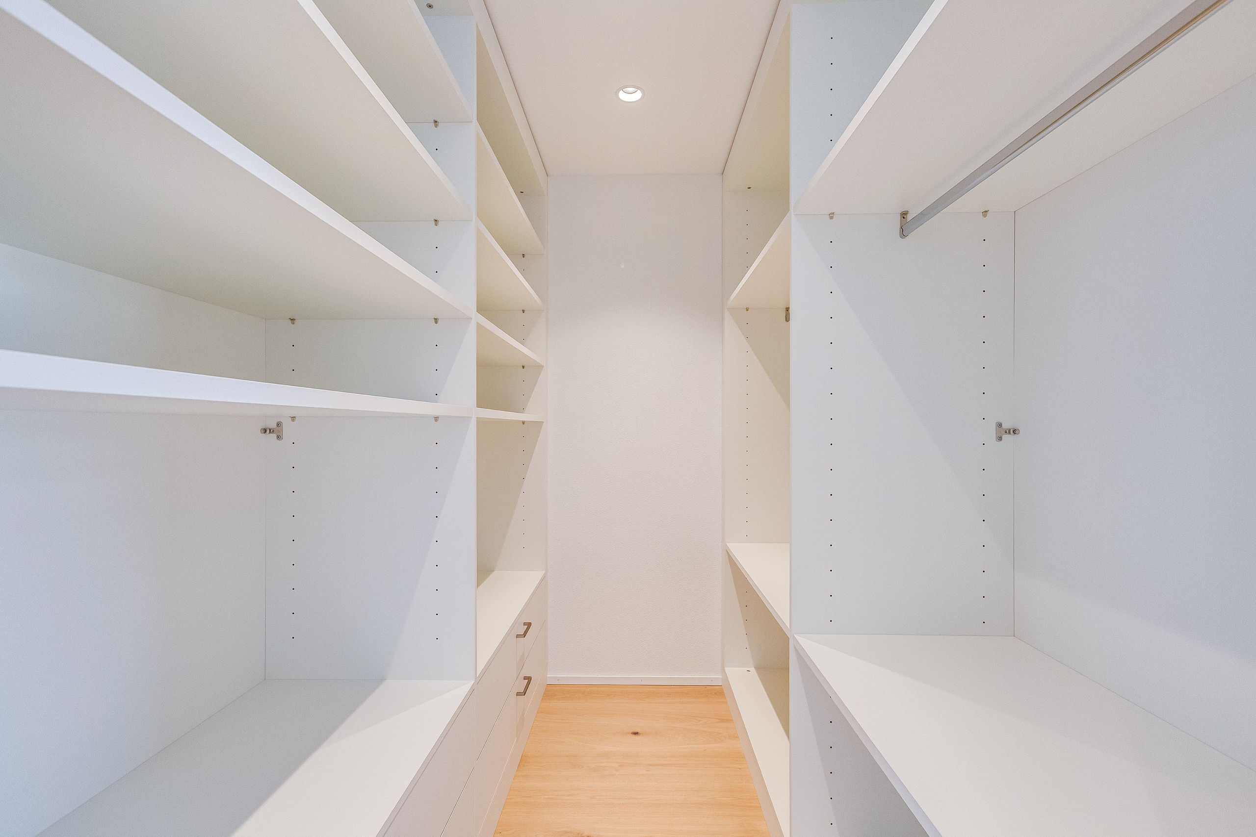 Begehbarer Kleiderschrank mit weißen Einbauten