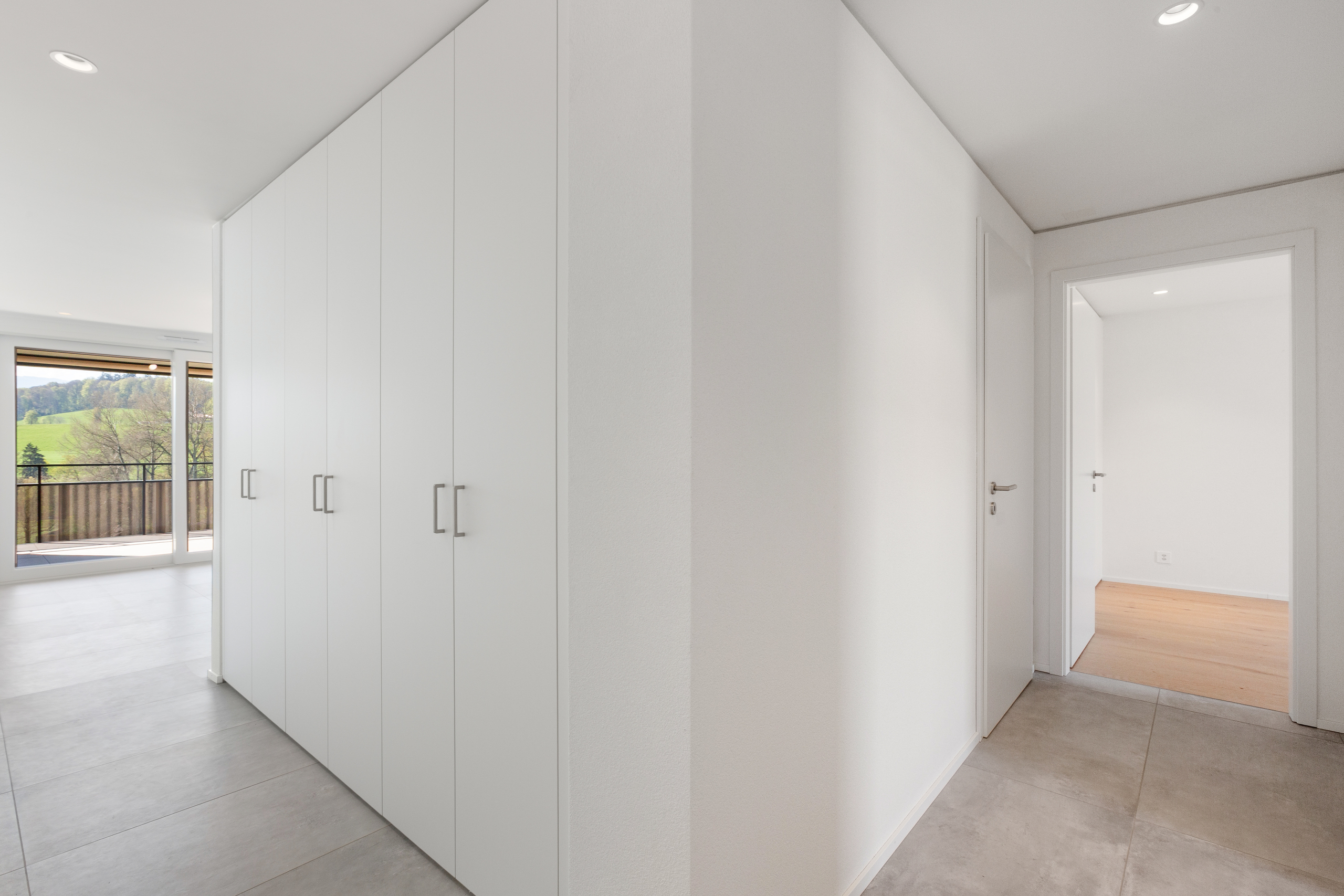 Heller Flur mit Einbauschrank und Blick ins angrenzende Zimmer