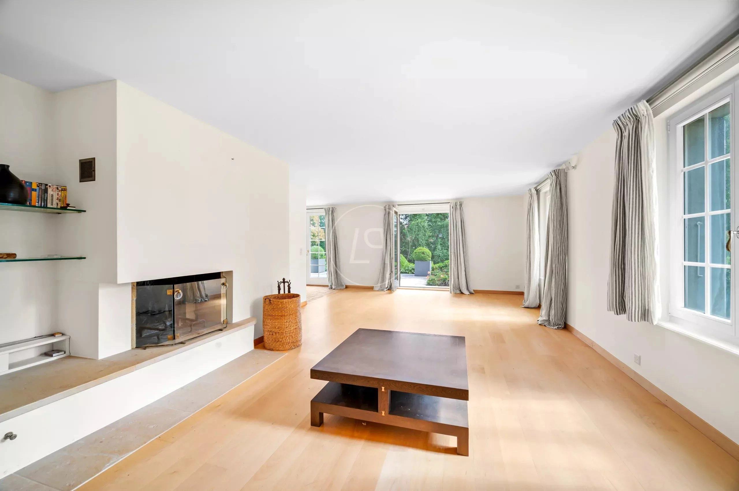 Heller Wohnraum mit Kamin und großen Fenstern
