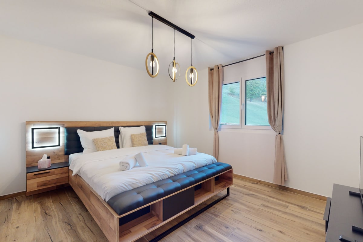 Schlafzimmer mit modernem Bett und Fensterblick