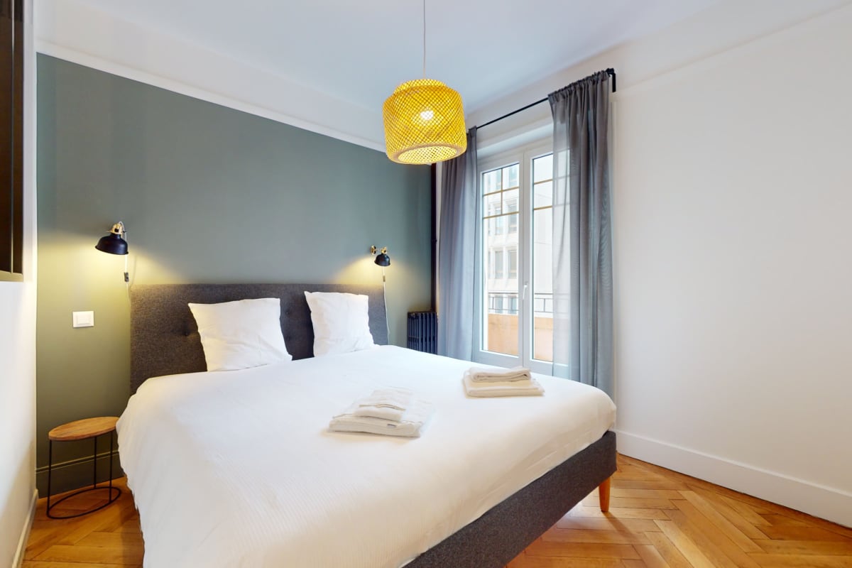 Helles Schlafzimmer mit Doppelbett und Balkonfenster