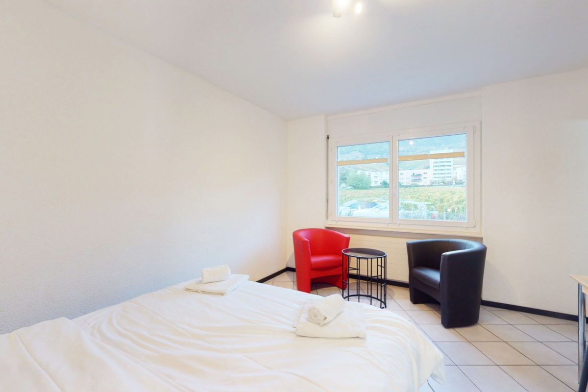 Helles Schlafzimmer mit Stühlen am Fenster