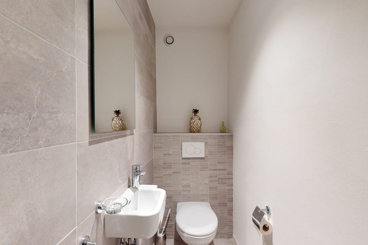 Modernes Gäste-WC mit beige-grauen Fliesen