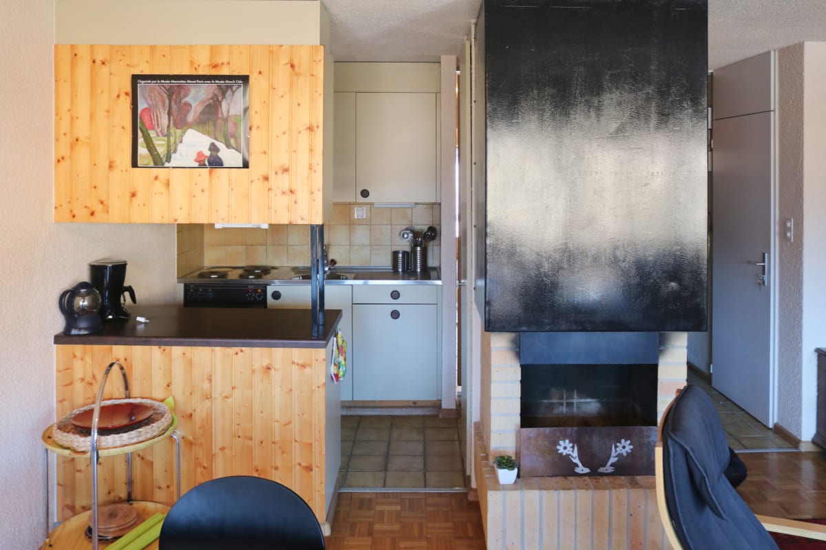 Wohnbereich mit offener Küchenzeile und Kamin