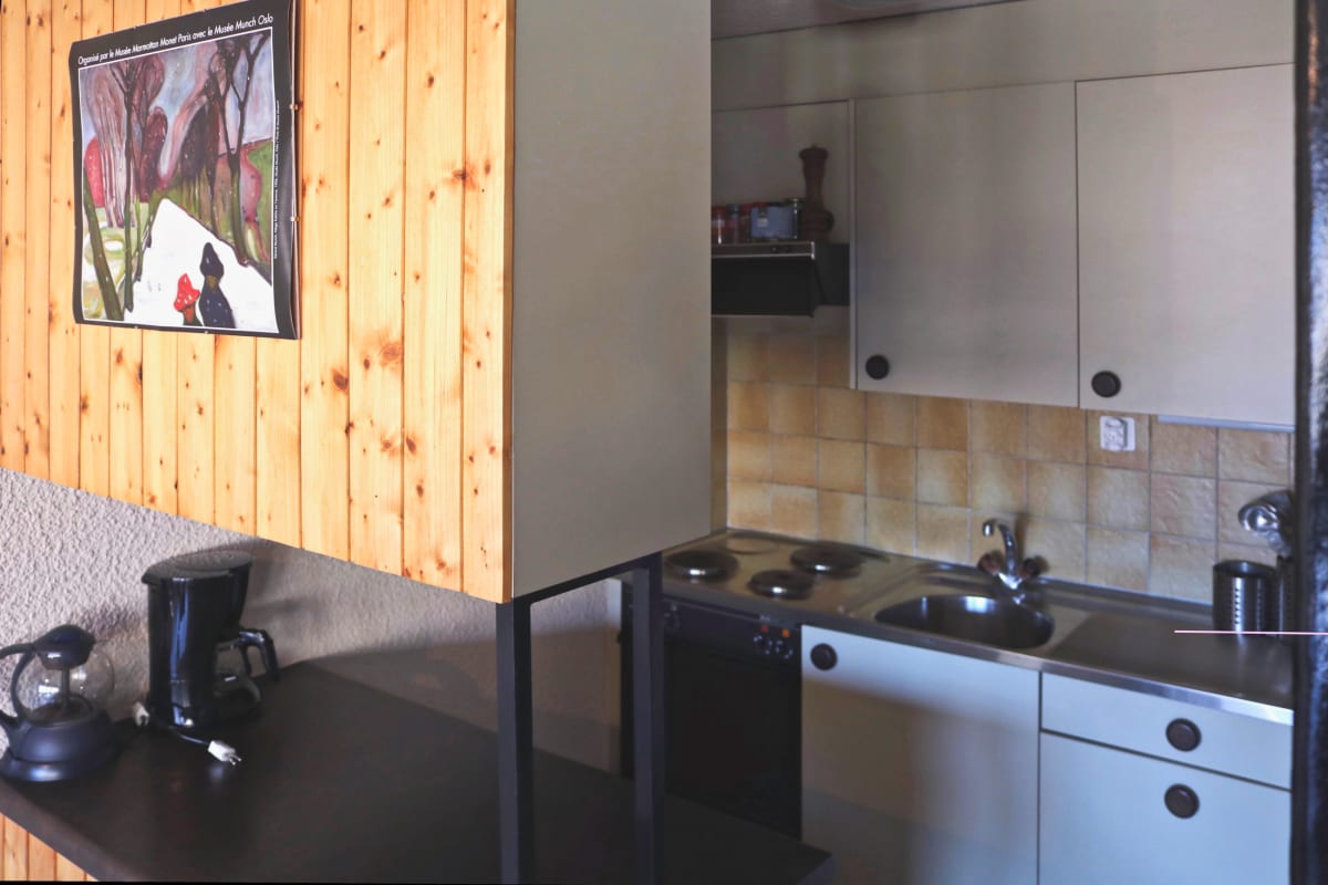 Kleine Küche mit Holzvertäfelung und dunkler Arbeitsfläche
