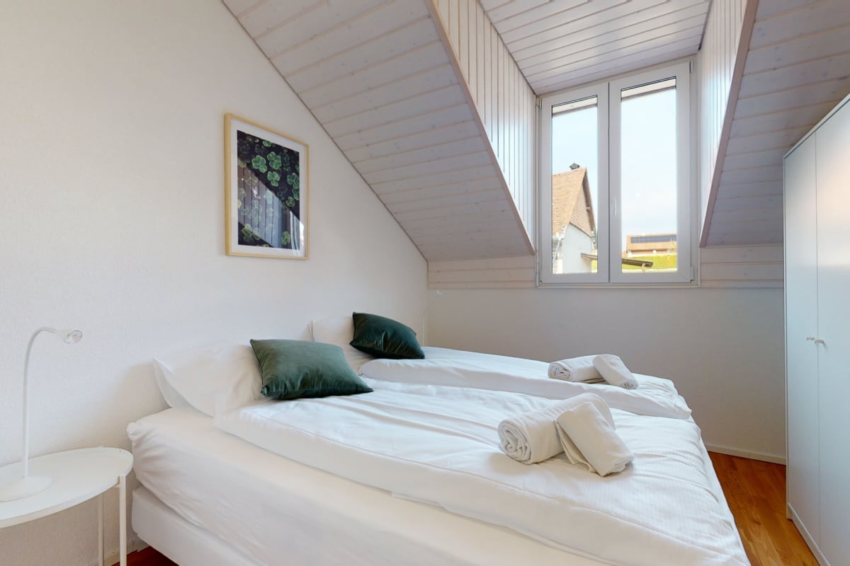 Dachgeschoss-Schlafzimmer mit großen Fenstern