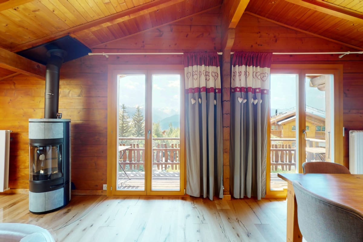 Gemütliches Holzinterieur mit Kaminofen und Balkonblick