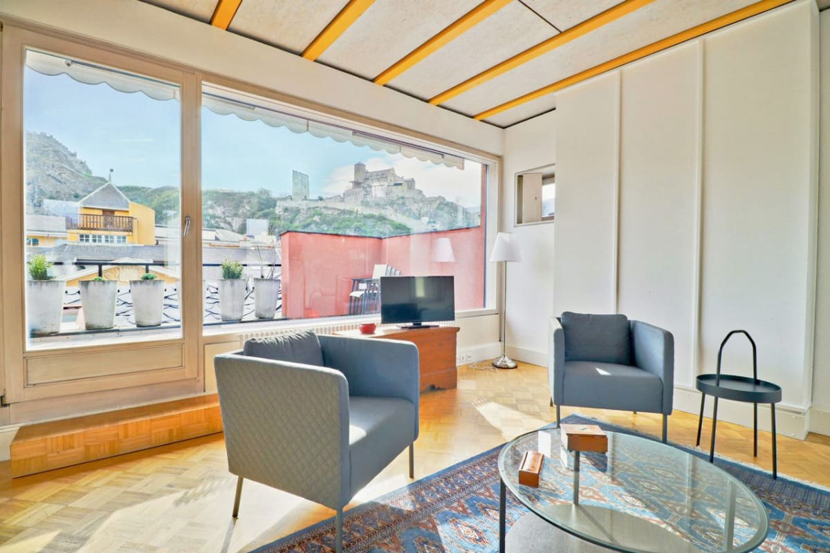 Helles Wohnzimmer mit großem Fenster und Terrasse