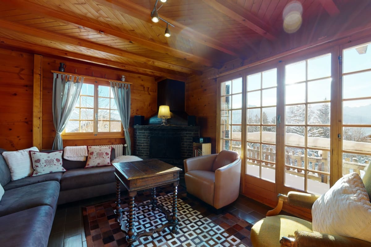 Gemütliches Holz-Wohnzimmer mit Kamin und Balkonblick