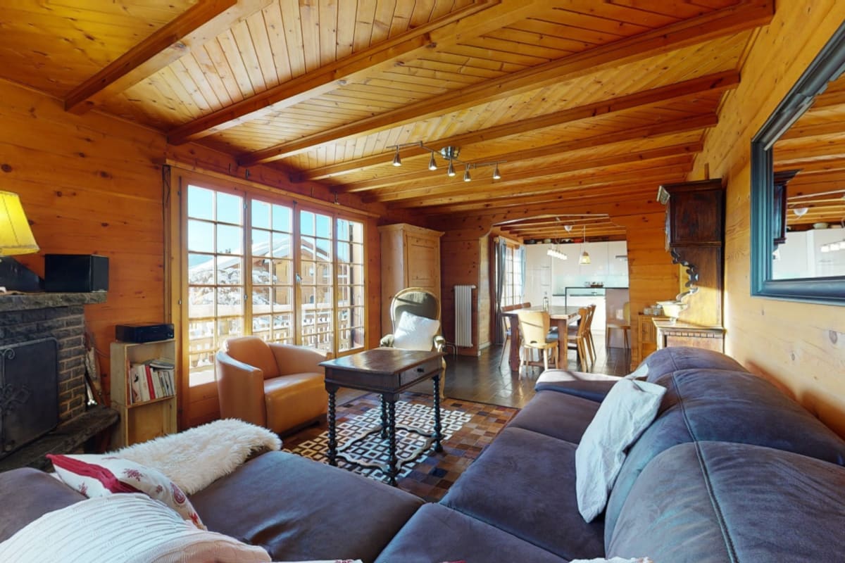 Gemütliches Holzwohnzimmer mit Blick in den Ess- und Küchenbereich