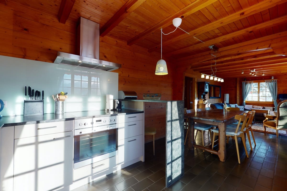 Offene Wohnküche mit Essbereich in rustikalem Holzinterieur