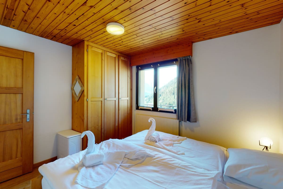 Gemütliches Schlafzimmer im Holzstil mit Bergblick