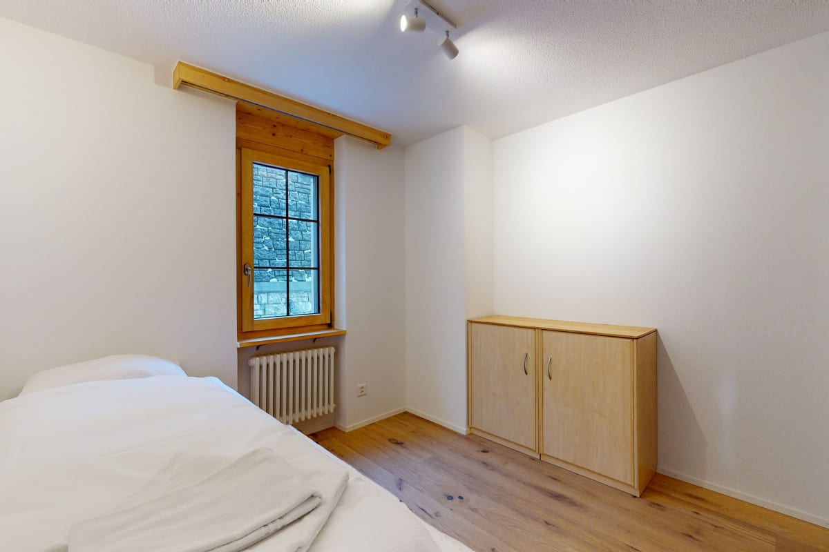 Helles Schlafzimmer mit Holzfenster und Sideboard