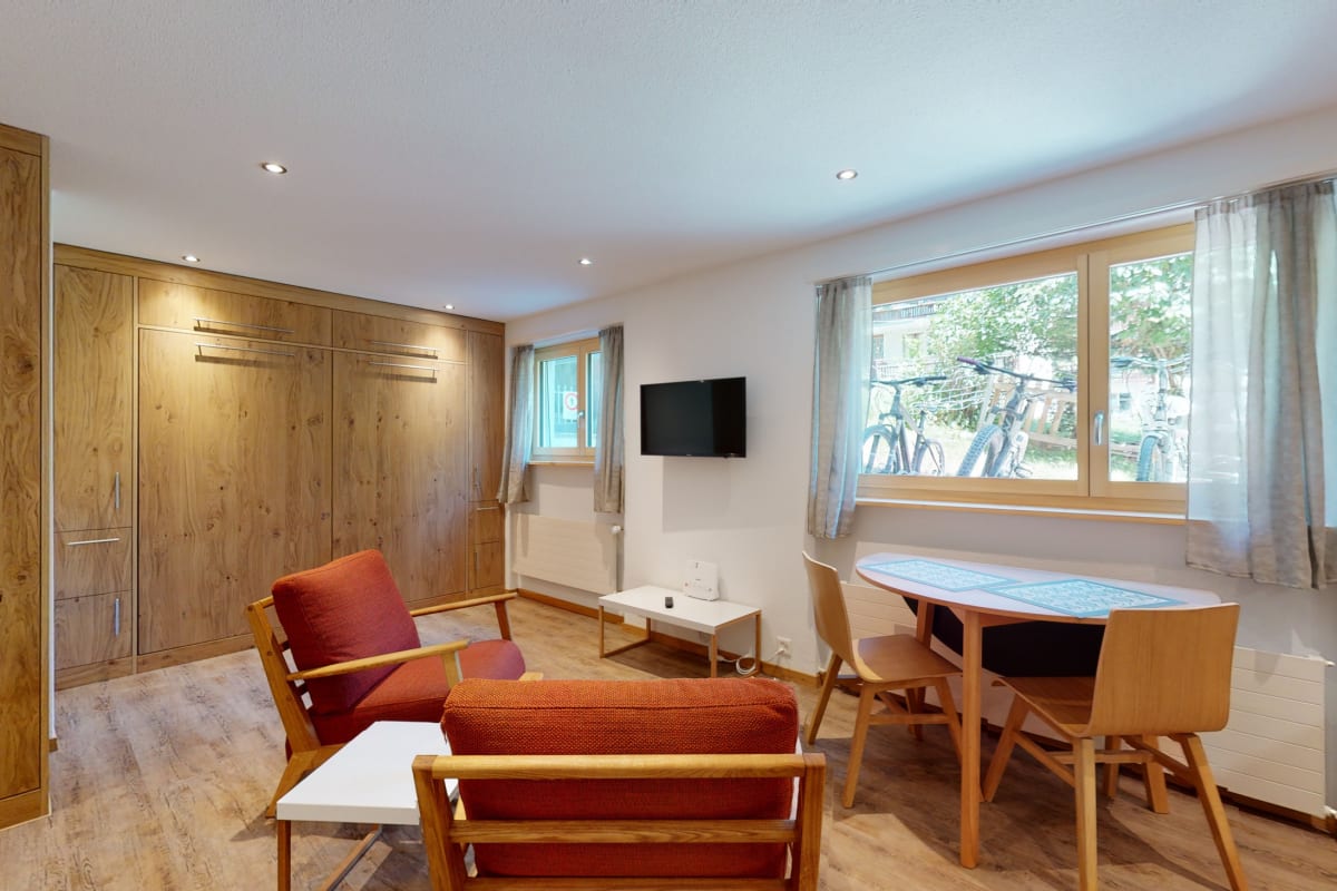 Wohnraum mit Holzschrankwand und Essbereich