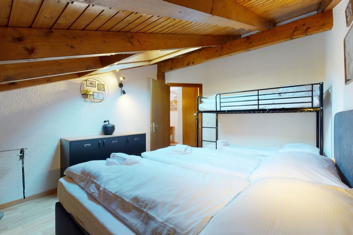 Dachgeschoss-Schlafzimmer mit Doppelbett und Hochbett