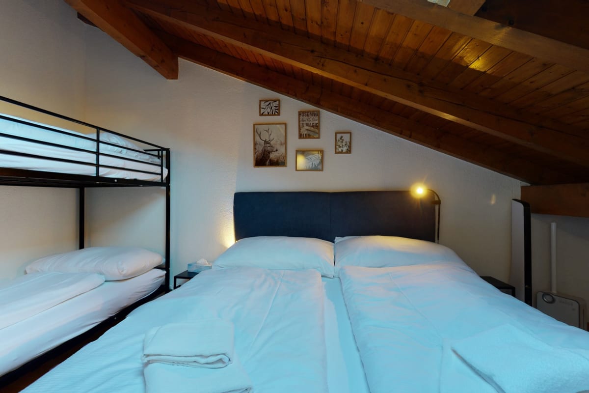 Dachgeschoss-Schlafzimmer mit Doppelbett und Etagenbett