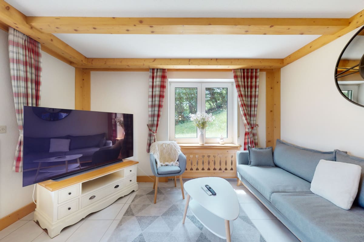Gemütliches Wohnzimmer mit Holzdecke und Blick ins Grüne