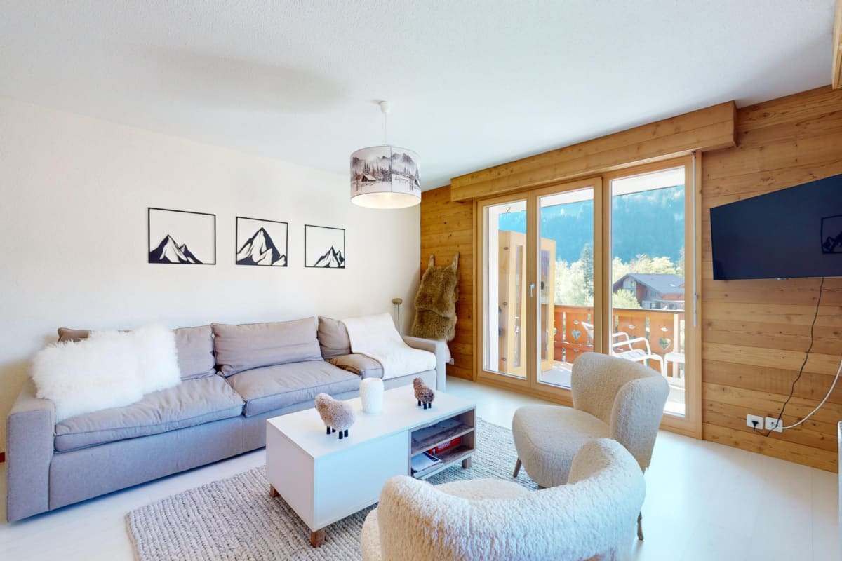Gemütliches Wohnzimmer mit Holzverkleidung und Bergblick