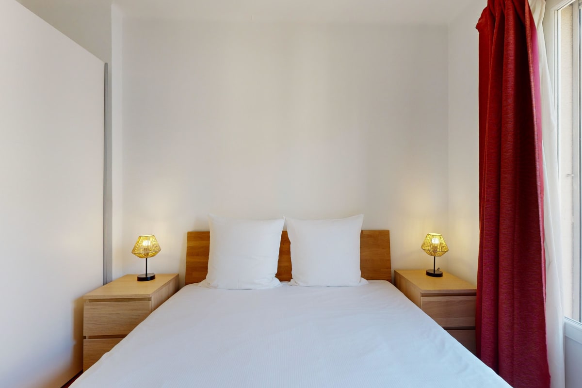 Helles Schlafzimmer mit Doppelbett und Nachttischlampen