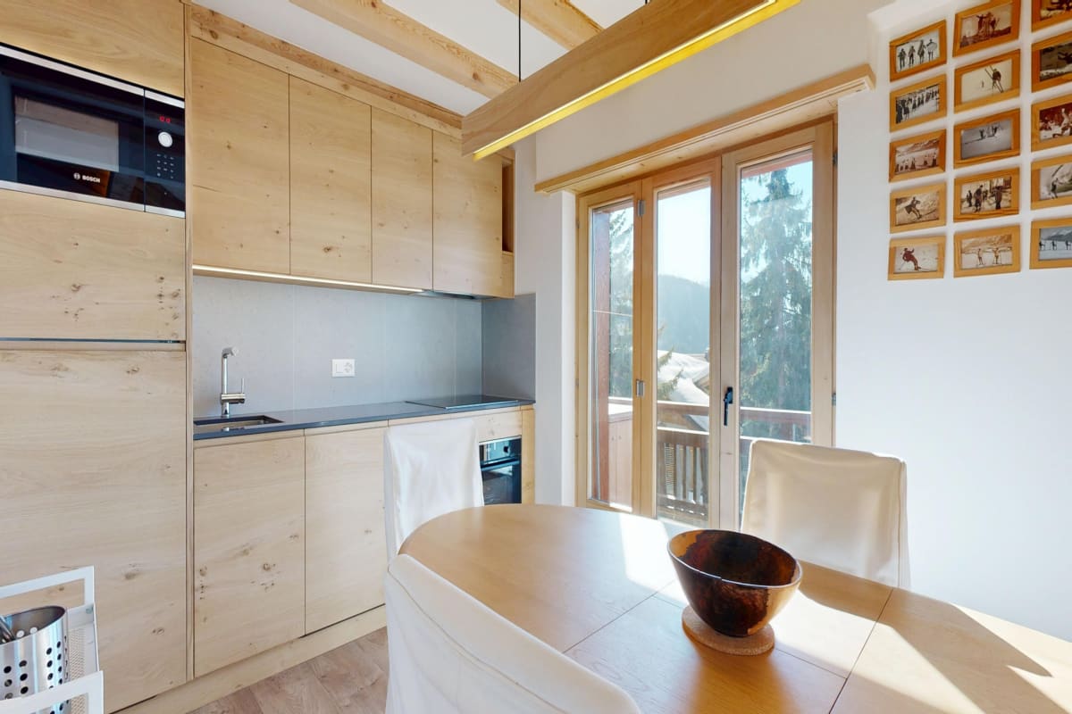 Helle Wohnküche mit Naturholz und Balkonblick