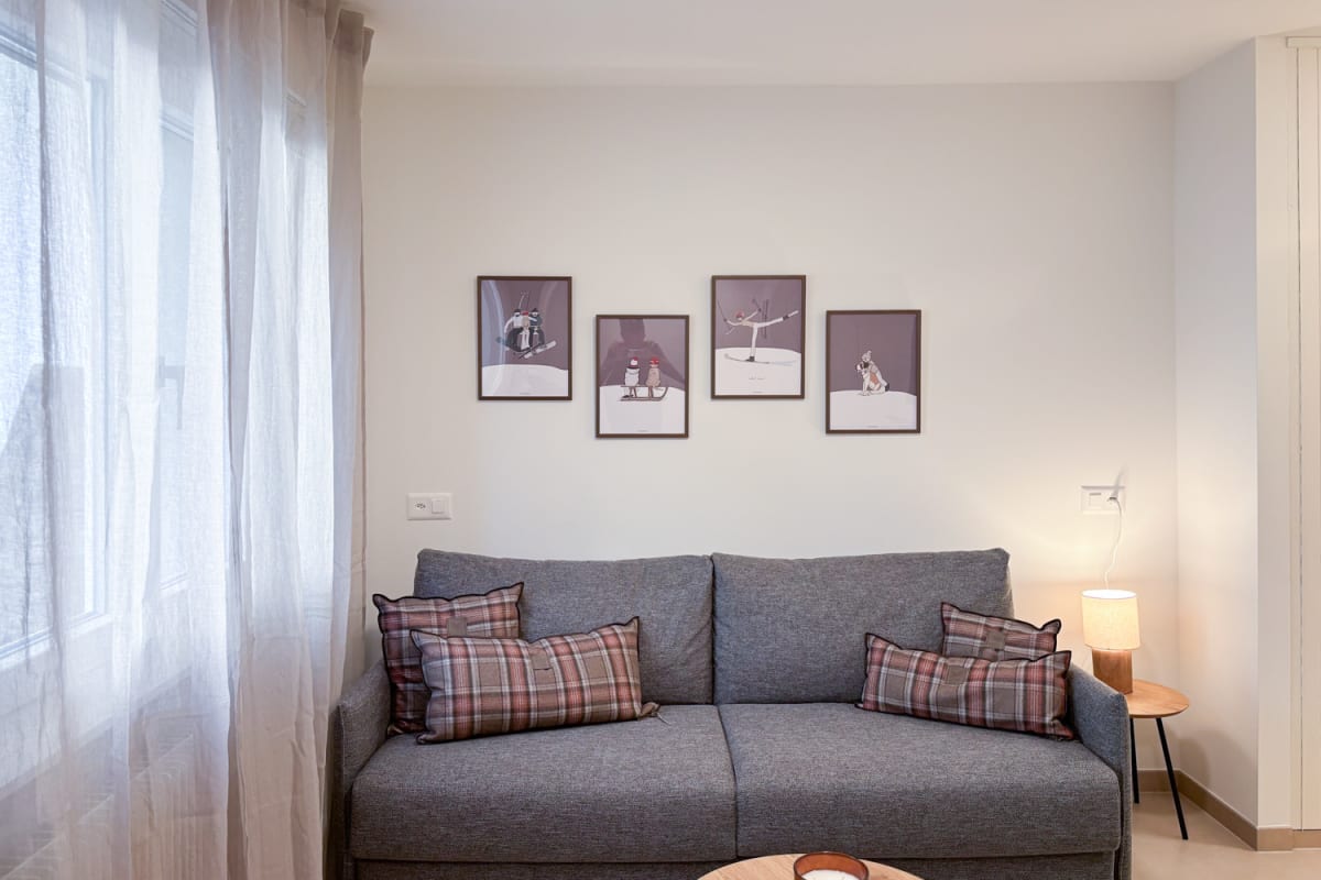 Gemütliches Wohnzimmer mit grauem Sofa und Fensterlicht