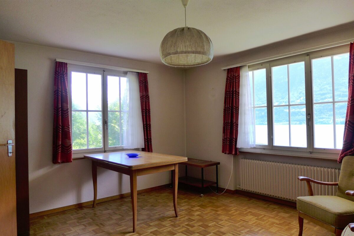 Helles Zimmer mit großen Fenstern und Holzmöbeln