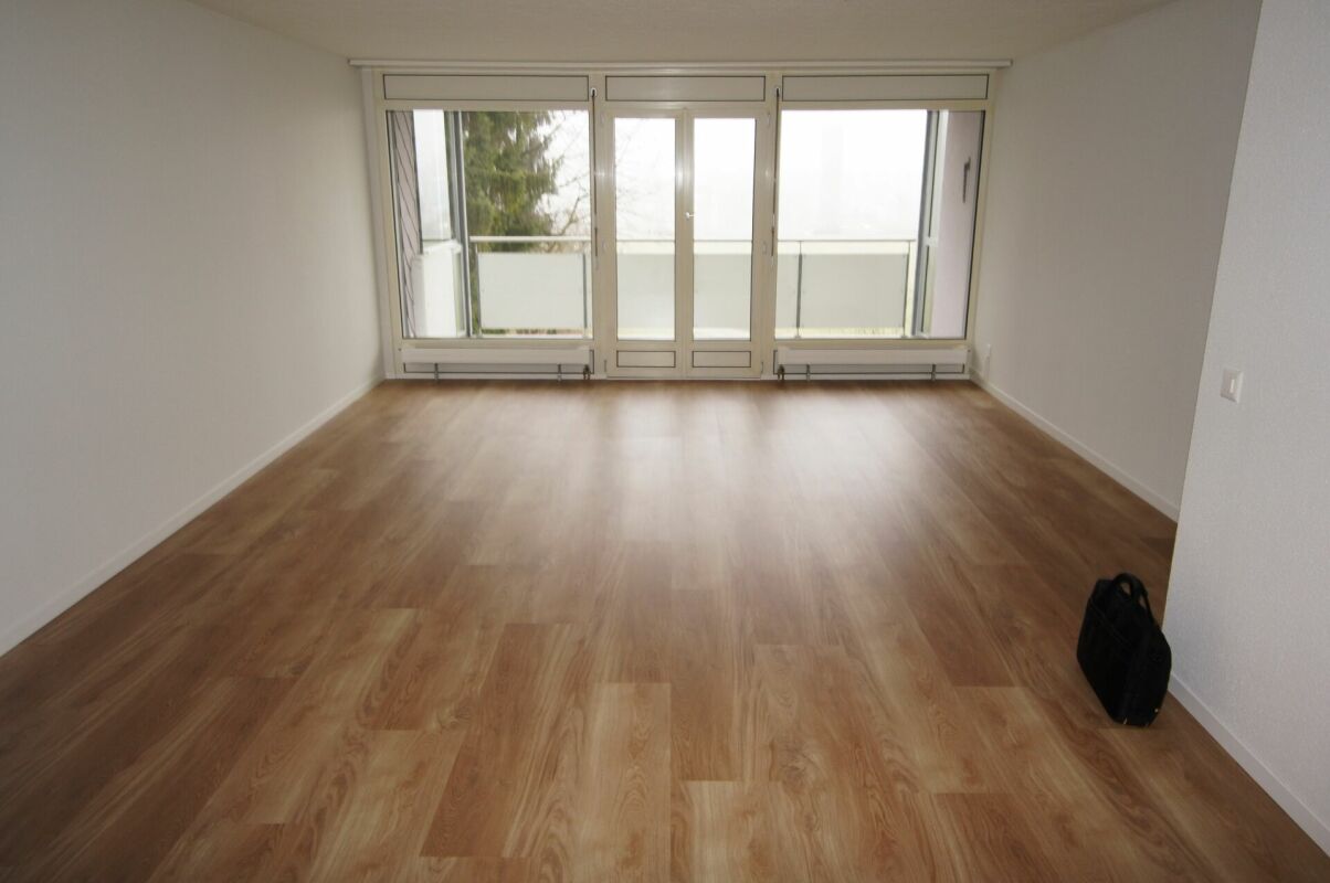 Leerer Wohnraum mit großem Balkonfenster