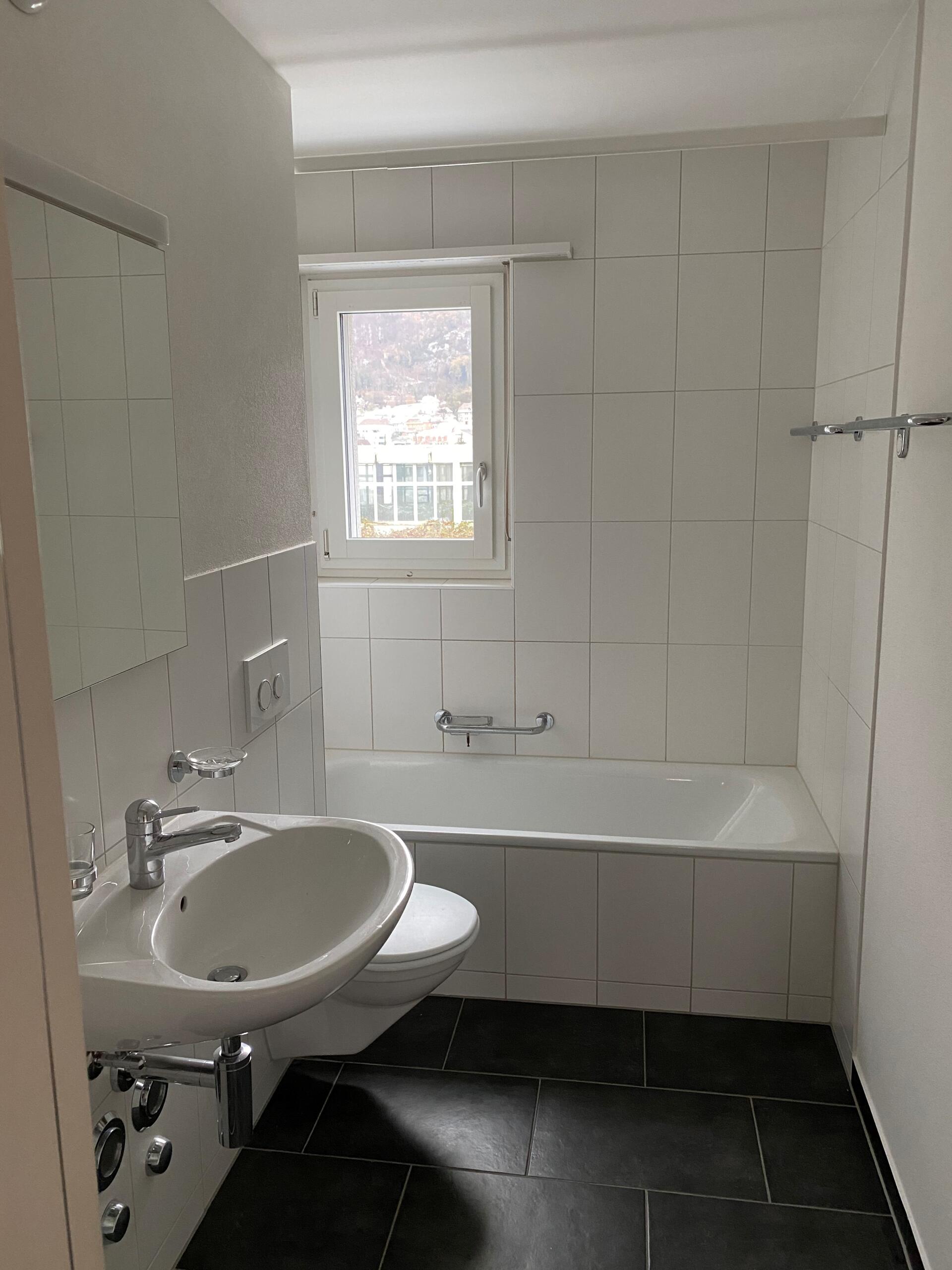Helles Badezimmer mit Wanne und Fenster