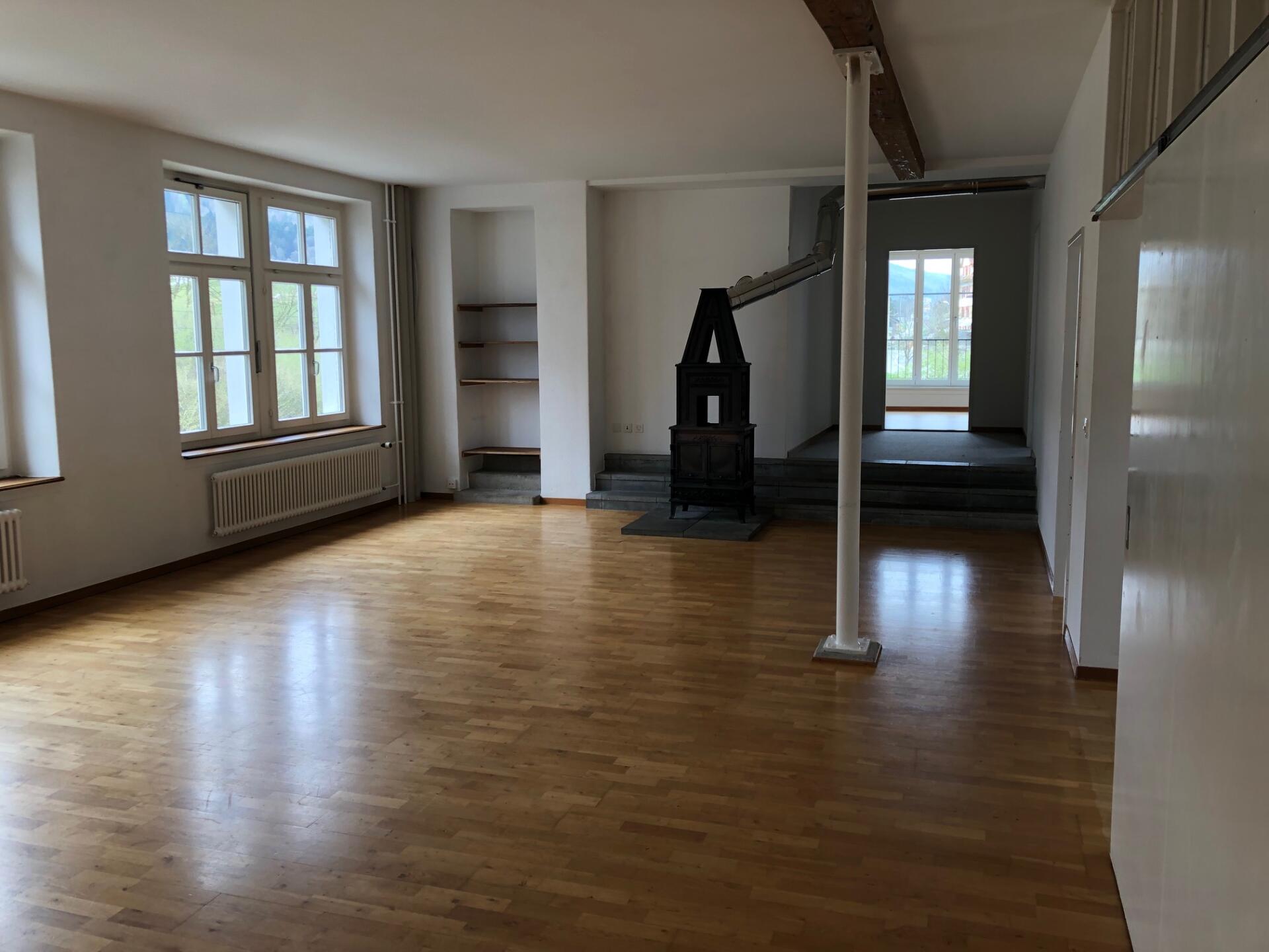 Großer leerer Wohnraum mit Kaminofen