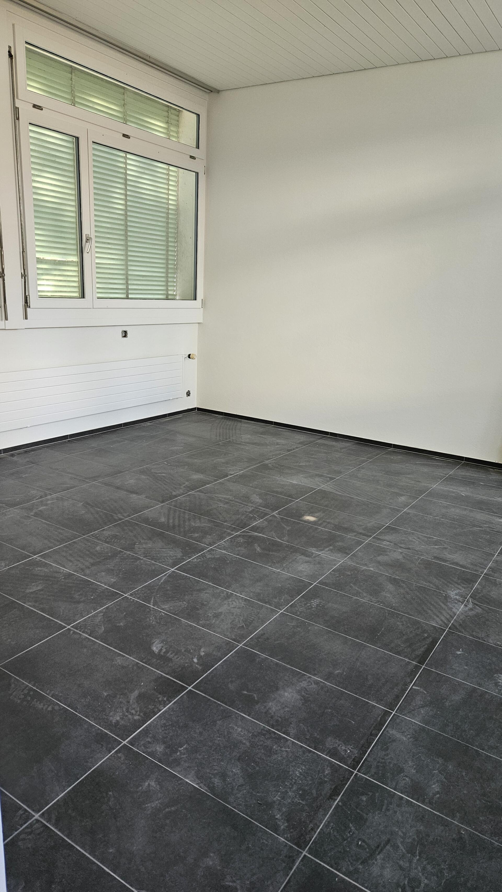 Leerer Raum mit Fliesenboden und Fenster