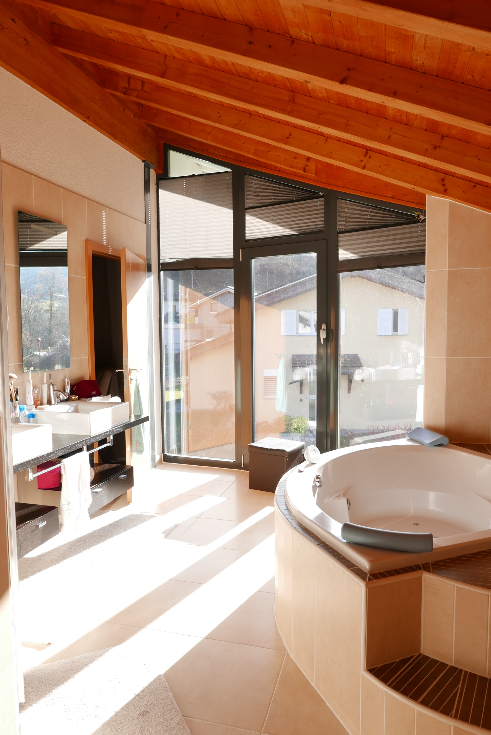 Helles Badezimmer mit Holzdecke und Whirlpool