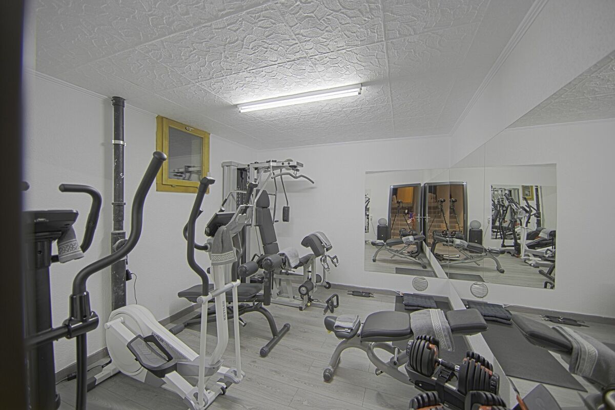 Heimfitnessraum mit Trainingsgeräten und Spiegelwand
