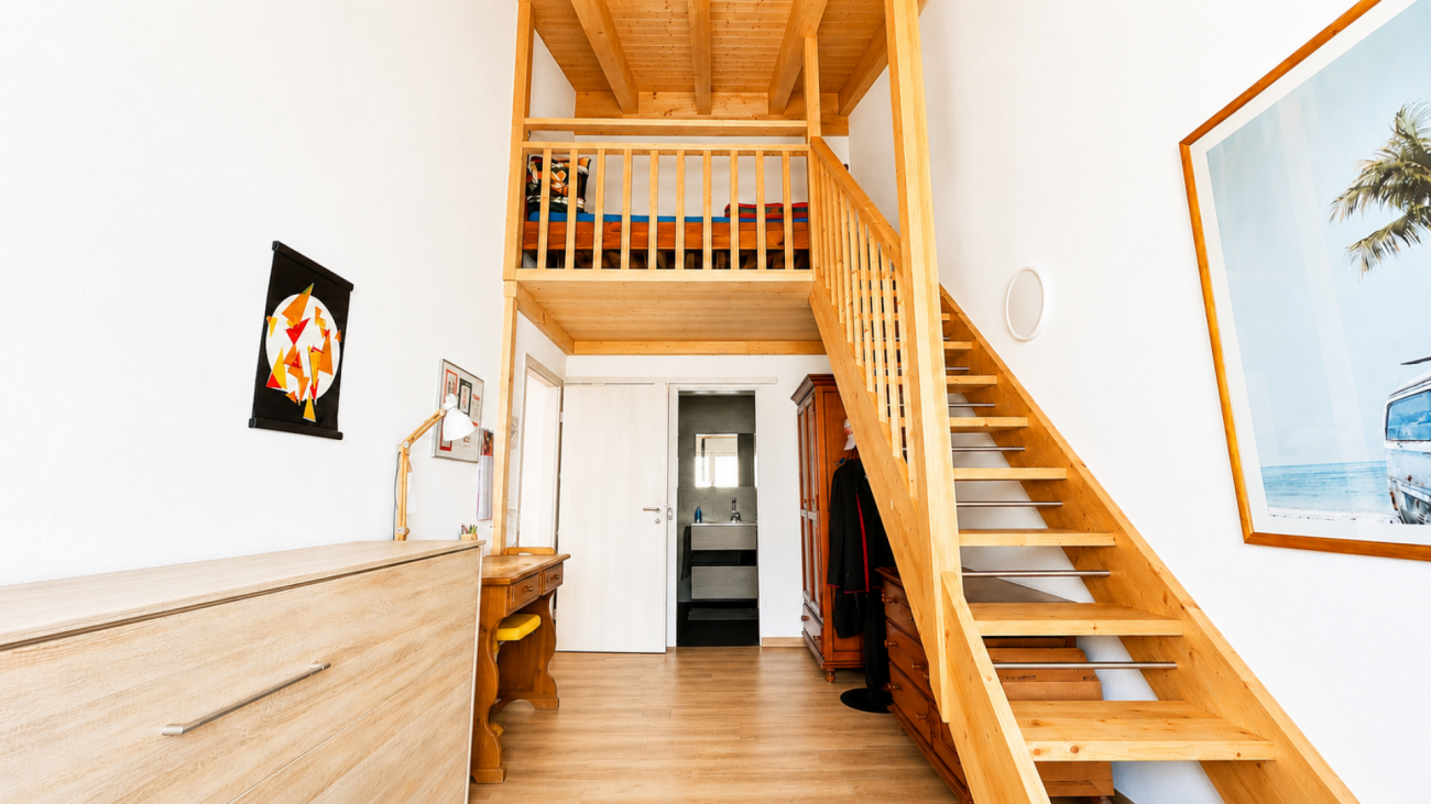 Heller Flur mit Holztreppe und Galerie