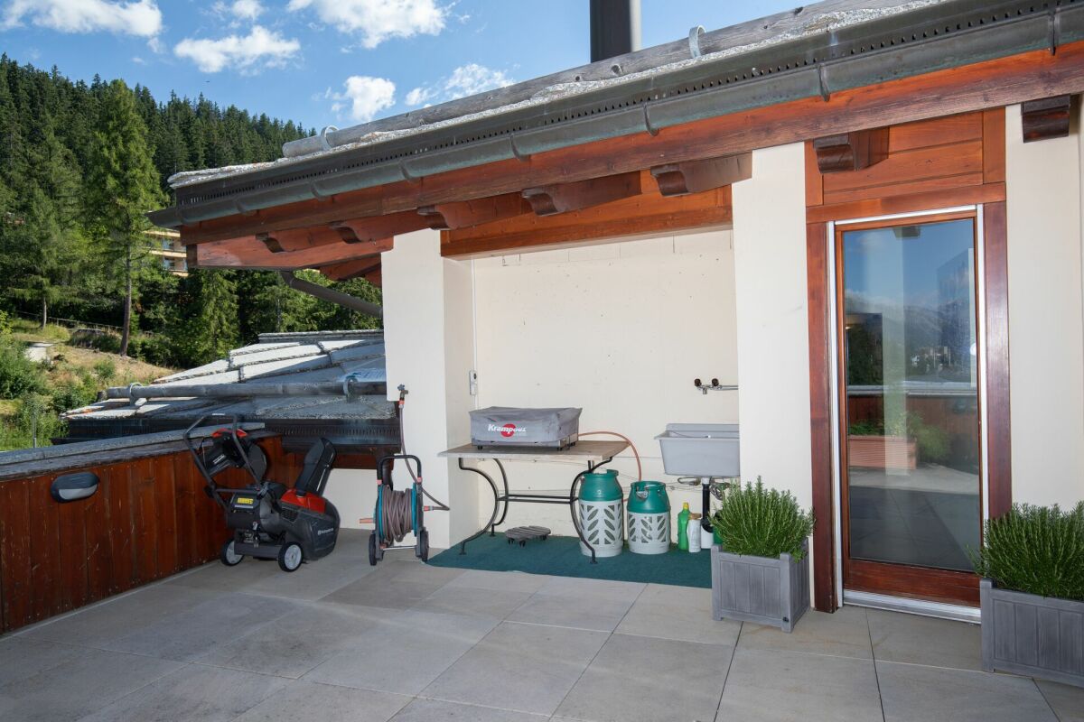 Überdachte Terrasse mit Grill- und Abstellbereich