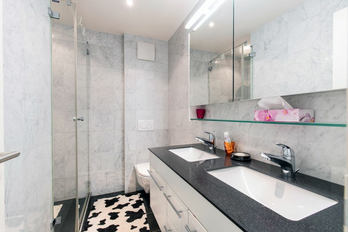 Modernes Badezimmer mit Doppelwaschtisch und Duschkabine