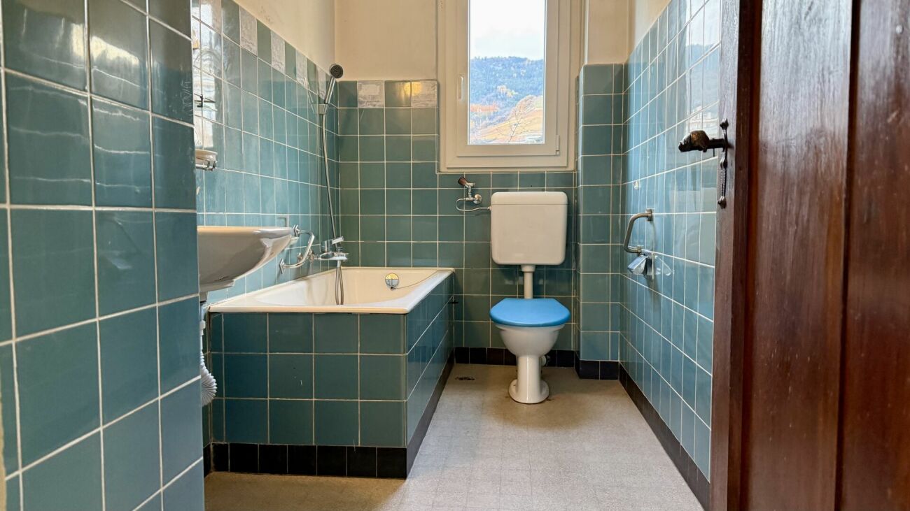Badezimmer mit türkisfarbenen Fliesen und Wanne
